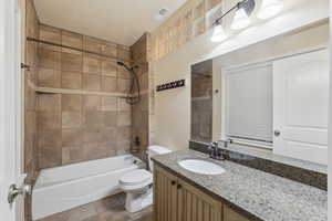 Full bathroom with toilet, vanity, and tiled shower / bath