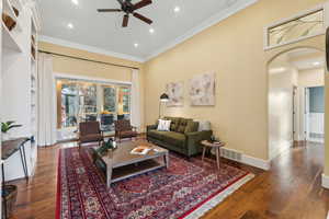 Living room with ceiling fan, crown molding, and hardwood floors