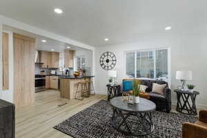 Living room with sink, light wood-type flooring, and a textured ceiling