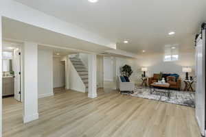 Living room featuring sink, a barn door, and light hardwood / wood-style flooring