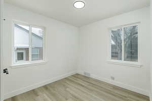 Empty room with light hardwood / wood-style floors