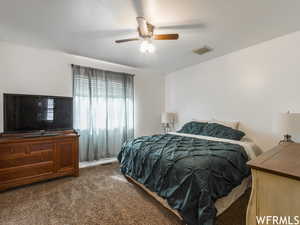 Carpeted bedroom featuring ceiling fan