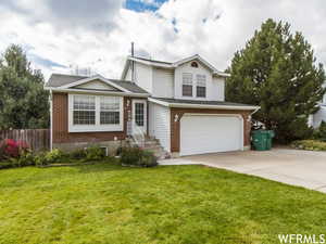 View of front of house featuring a front yard and a garage