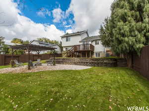 View of yard with a pergola, a fire pit, a wooden deck, and a patio