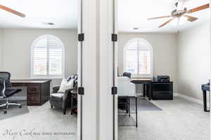 Carpeted home office with ceiling fan