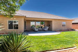 Rear view of property with a patio area and a lawn