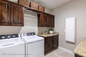 Washroom with light tile patterned flooring, cabinets, and independent washer and dryer