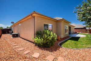 View of side of property with a patio, central AC, and a yard