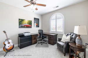 Carpeted home office featuring ceiling fan