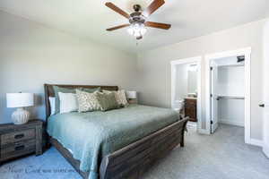 Carpeted bedroom featuring ceiling fan and ensuite bathroom