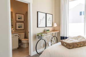 Tiled bedroom featuring ensuite bathroom