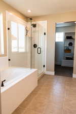 Bathroom featuring tile patterned flooring and shower with separate bathtub