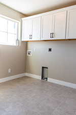 Laundry room featuring electric dryer hookup, light tile patterned floors, cabinets, and hookup for a washing machine