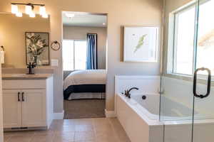 Bathroom featuring tiled tub, tile patterned floors, and plenty of natural light