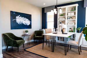 Dining room featuring built in features, a notable chandelier, and dark wood-type flooring