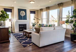 Living room with a fireplace and dark hardwood / wood-style flooring