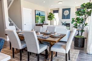 Dining area with a large fireplace and dark wood-type flooring