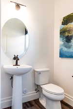 Bathroom featuring toilet, sink, and hardwood / wood-style floors