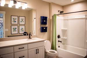 Full bathroom featuring shower / bathtub combination with curtain, vanity, and toilet