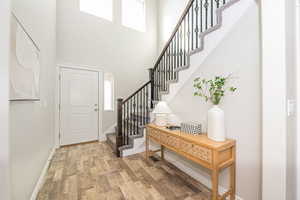 Foyer entrance with a towering ceiling and hardwood / wood-style floors