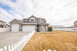 View of front of house with solar panels, a front yard, and a garage