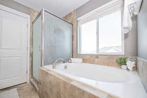 Bathroom featuring a healthy amount of sunlight and independent shower and bath