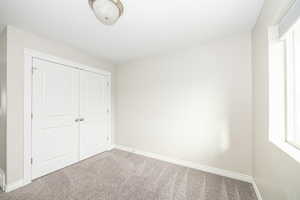 Unfurnished bedroom featuring a closet and carpet floors