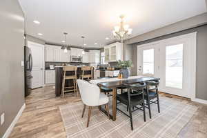 Dining area with an inviting chandelier, light hardwood / wood-style floors, and sink