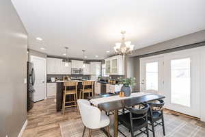 Dining room featuring an inviting chandelier and light hardwood / wood-style flooring