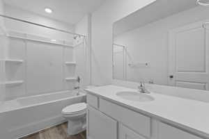 Full bathroom featuring bathtub / shower combination, toilet, vanity, and LVP flooring