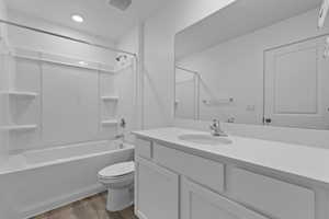 Full bathroom featuring toilet, vanity, LVP flooring, and bathtub/shower combination