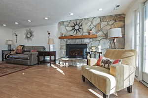 Living room featuring a fireplace, light wood-type flooring, and crown molding