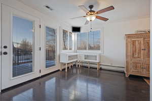 Unfurnished dining area with dark wood-type flooring, ceiling fan, baseboard heating, and ornamental molding