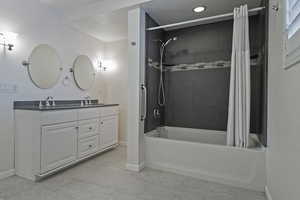 Bathroom featuring vanity, tile patterned flooring, and shower / bath combo with shower curtain