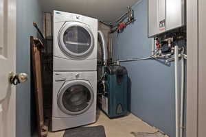 Clothes washing area with tankless water heater and stacked washer and dryer