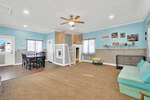 Interior space with ceiling fan, a wealth of natural light, connected to dining area and access to the yard