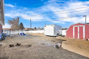 View of yard featuring a playground and a shed