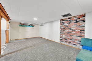 Basement living room featuring new carpet flooring and included projector