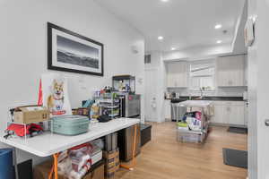 Kitchen with white cabinets, light wood-type flooring, and sink