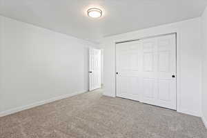 Unfurnished bedroom featuring a closet and carpet flooring