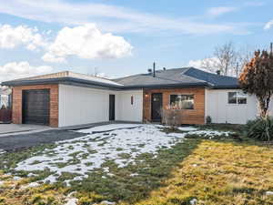 Single story home with a front lawn and a garage