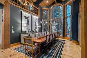 Dining room featuring wood ceiling, light hardwood / wood-style flooring, high vaulted ceiling, and beamed ceiling