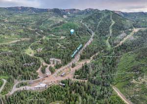 Aerial overview of property's location with a mountain backdrop and property boundaries highlighted