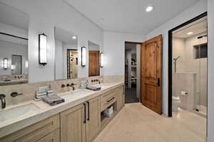 Bathroom featuring toilet, tasteful backsplash, tile patterned floors, an enclosed shower, and vanity