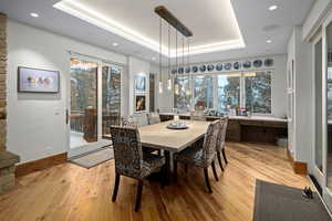 Dining space featuring a raised ceiling and light hardwood / wood-style flooring