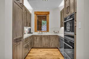 Kitchen with light wood-style floors, dishwasher, and light countertops