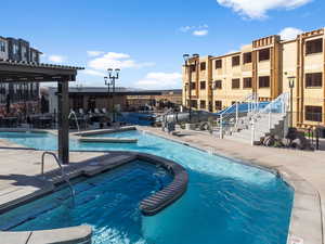 View of swimming pool with a jacuzzi and a patio