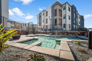 View of swimming pool with a hot tub