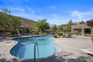 View of swimming pool featuring an in ground hot tub, a mountain view, and a patio area