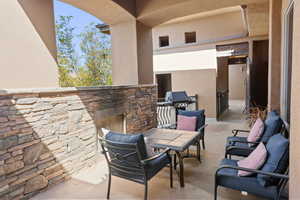 View of patio featuring a grill and an outdoor stone fireplace